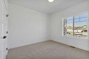 Unfurnished room with carpet flooring and a residential view