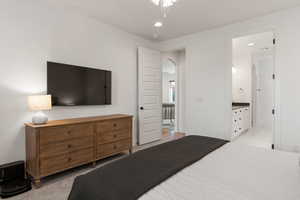 Bedroom featuring arched walkways, recessed lighting, and connected bathroom