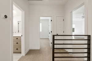 Hallway featuring baseboards and light colored carpet