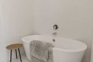 Full bath with a freestanding bath and tile patterned floors