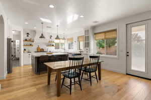 Dining area featuring light wood-style flooring, recessed lighting, and a skylight