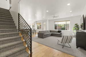 Living room with recessed lighting, light wood finished floors, healthy amount of natural light, stairs, and ceiling fan