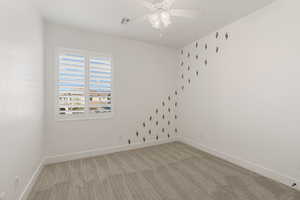 Empty room with light carpet and a ceiling fan
