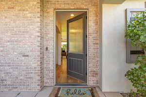 Property entrance with brick siding and stucco siding