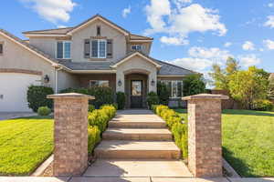 View of front of home featuring a front lawn, stucco siding, brick siding, and a tile roof