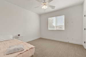 Bedroom with light colored carpet and ceiling fan