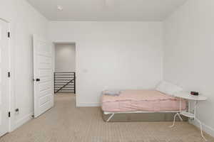 Bedroom with light colored carpet and baseboards