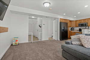Living area with light colored carpet and recessed lighting