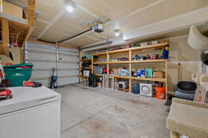 Garage with a garage door opener and white fridge