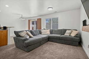 Living area with carpet flooring, a textured ceiling, a chandelier, and recessed lighting