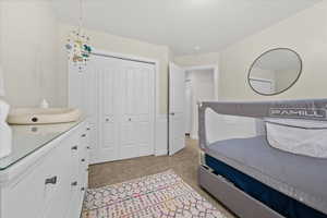 Bedroom featuring light carpet and a closet