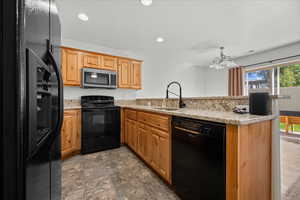 Kitchen featuring black appliances, plenty of natural light, recessed lighting, a peninsula, and Granite countertops