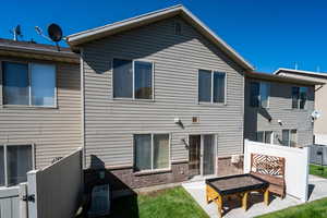 Back of property with brick siding, a patio area, and a gate