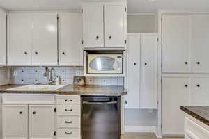 Kitchen with dishwasher, white cabinets, and a textured ceiling
