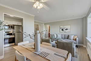 Dining room featuring crown molding, light wood finished floors, radiator, and ceiling fan