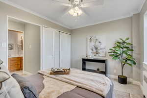 Bedroom featuring crown molding, light colored carpet, a closet, a ceiling fan, and radiator
