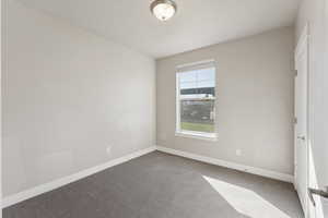 Carpeted empty room featuring baseboards