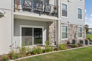 Entrance to property featuring stone siding and a lawn