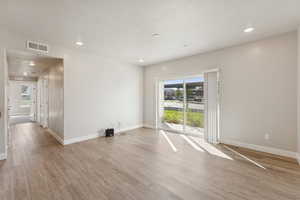 Spare room featuring light wood finished floors and recessed lighting