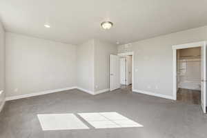 Unfurnished bedroom featuring carpet floors, recessed lighting, and ensuite bath