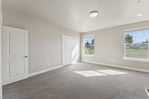 Unfurnished bedroom with baseboards and carpet