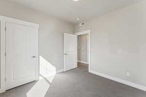 Unfurnished bedroom with carpet floors and baseboards