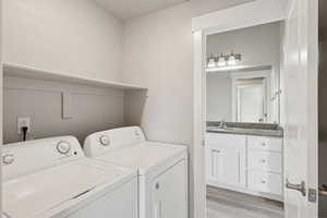 Washroom with light wood finished floors and separate washer and dryer