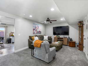 Carpeted living area with ceiling fan, recessed lighting, and tile patterned floors