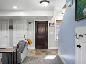Foyer entrance featuring baseboards and carpet flooring