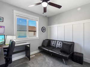 Carpeted office with ceiling fan and baseboards