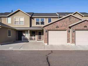 Traditional home featuring a porch, stucco siding, and a shingled roof