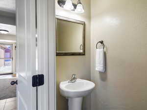 Bathroom with tile patterned flooring and a textured wall