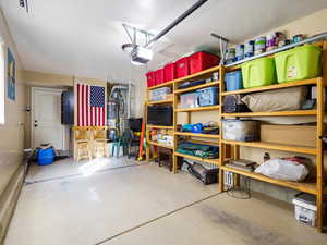 Garage featuring water heater and a garage door opener