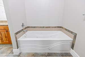 Primary bathroom featuring a jetted tub and double vanity