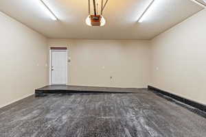 Garage with baseboards and a garage door opener