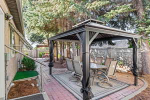 Fenced backyard with a gazebo, a patio area, and outdoor dining area