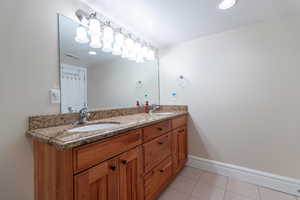 Full bath with light tile patterned floors, double vanity, a textured ceiling, and recessed lighting