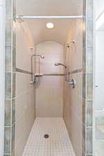 Primary Bathroom featuring a tile shower, a textured ceiling, and recessed lighting