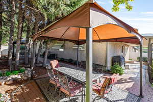 View of patio featuring a gazebo, outdoor dining area, and a grill