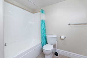 Bathroom with tile patterned floors and shower / bath combo with shower curtain