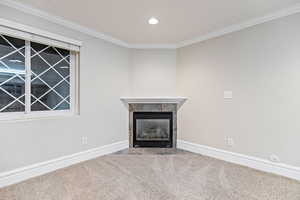 Large living room featuring crown molding, a fireplace, carpet floors, and recessed lighting