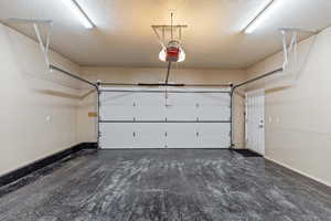 Garage with baseboards and a garage door opener