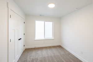 Unfurnished bedroom featuring light colored carpet and a closet