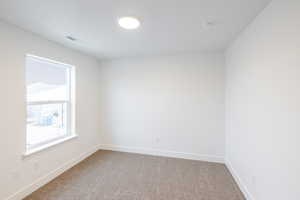 Carpeted spare room with baseboards