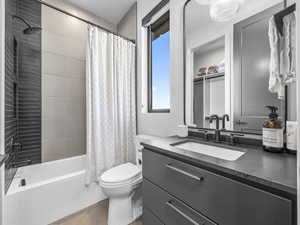 Bathroom featuring vanity, shower / bathtub combination with curtain, and tile patterned floors