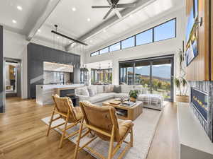 Living room with light wood-style flooring, beamed ceiling, a fireplace, a mountain view, and recessed lighting
