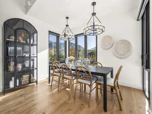 Dining area with a mountain view, light wood-style flooring, and a chandelier