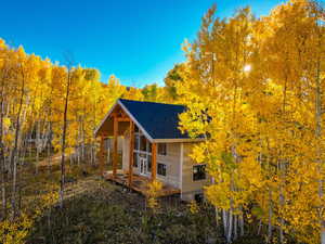 View of side of property with roof with shingles
