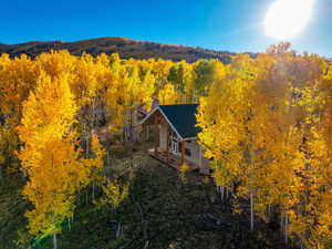 Aerial view of property and surrounding area with a heavily wooded area