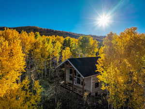 Aerial view of property and surrounding area with a heavily wooded area